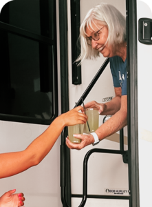 Concierge at The Regatta on Grand luxury RV resort delivering drinks to a resort guest.