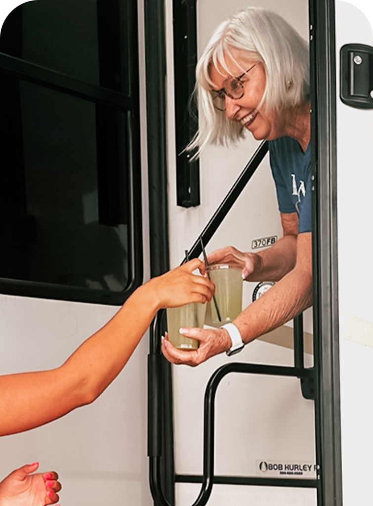 Concierge at The Regatta on Grand luxury RV resort delivering drinks to a resort guest.