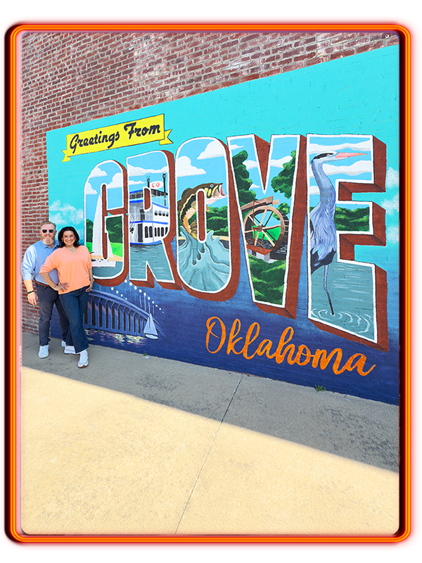 Amy and Patrick Wells at Greetings From Grove, Oklahoma Mural near Grand Lake O' the Cherokees.